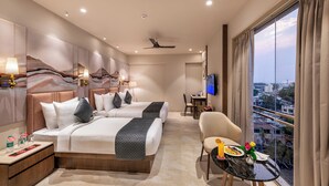 Quarto de hotel com cama, mesa de cabeceira, cadeira, televisão e varanda com vista para a cidade.