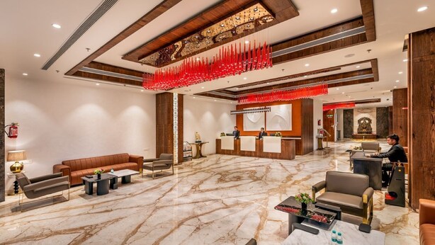 Um hall amplo com piso de mármore, sofás de couro e um balcão de recepção.