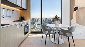 Eine moderne Küche mit Blick auf die Stadt, ein Essbereich mit Stühlen und ein großes Fenster.
