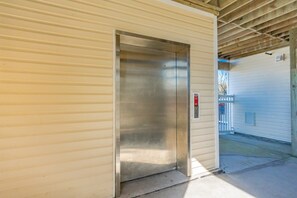 An elevator in a building with a metal exterior and a wooden ceiling. - Surf City Hideaway - Cozy 2BR at Tiffany's Motel; Comm. Pool! (Surf City)