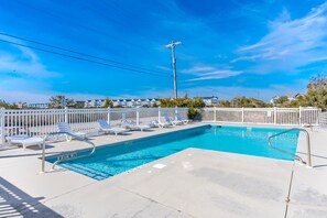 A rectangular swimming pool with a white fence and lounge chairs. - Surf City Hideaway - Cozy 2BR at Tiffany's Motel; Comm. Pool! (Surf City)