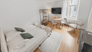 Una habitación de hotel moderna con cama, escritorio, silla y televisor.