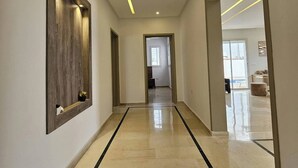 A modern hallway with a polished floor, recessed lighting, and a wooden accent wall. - Luxurious Villa Rental in Houmt Souk, Djerba - Perfect Family Retreat (Houmt Souk)