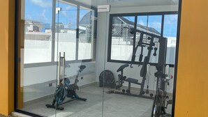 A gym with exercise equipment, a large glass door, and a view of the outside. - Luxury and Peace Near Downtown Puntacana (Punta Cana)