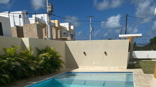 A rectangular swimming pool with clear blue water, surrounded by a tiled deck. - Luxury and Peace Near Downtown Puntacana (Punta Cana)