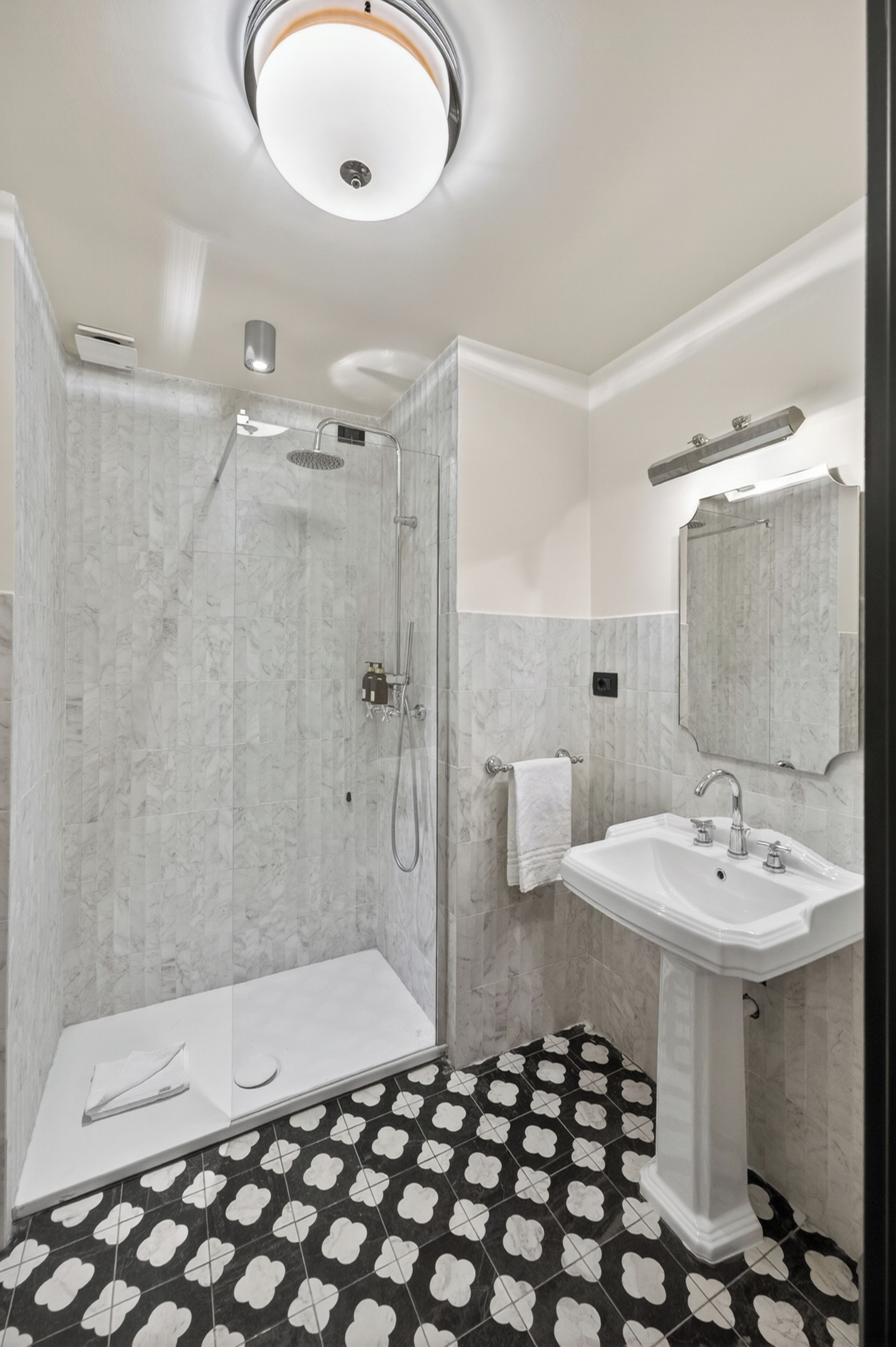 A bathroom with a shower, a sink, and a mirror.