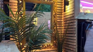 A wooden exterior wall with a decorative mirror, potted plants, and a bench. - Stylish City Centre Hideaway & Hot Tub (Galway)