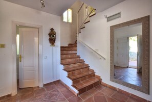 A staircase with wooden steps and white railings, a large mirror on the wall, and a door leading to another room. - Charming villa with private pool in Mijas Costa (Mijas)