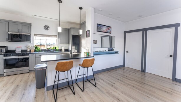 Een moderne keuken met roestvrijstalen apparatuur, een groot kookeiland met barkrukken en uitzicht op de omgeving.