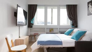 A modern hotel room with a bed, a desk, a chair, and a TV. - Modern apartment with plenty of public transport! (Neuilly-sur-Seine)