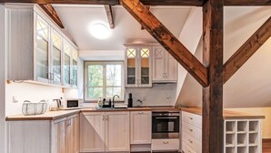 Una cocina con armarios de madera, horno empotrado y ventana.