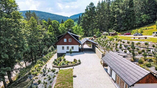 Una casa con piscina, rodeada de un jardín y un viñedo.