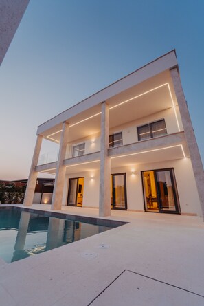 A modern two-story building with a swimming pool in the foreground. - Villa Turnea With Heated Pool (Sveti Filip i Jakov)