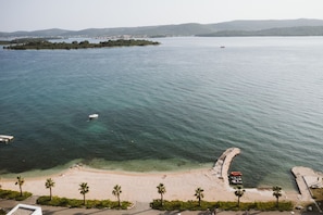 A coastal view with a beach, clear water, and a small island in the distance. - Villa Turnea With Heated Pool (Sveti Filip i Jakov)