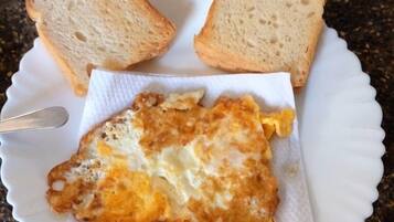 A plate with a fried egg and two slices of bread on a granite countertop.