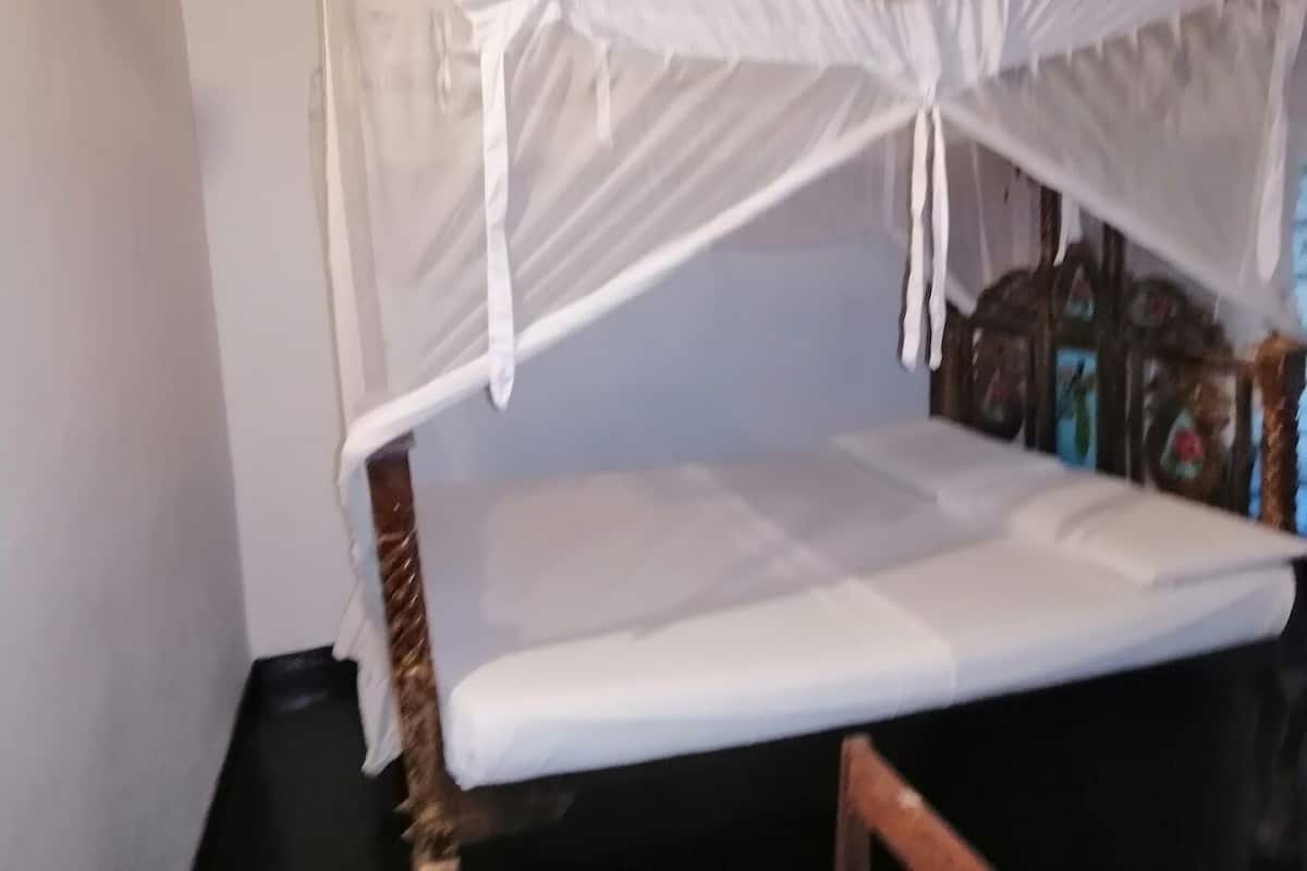Un lit superposé avec une moustiquaire.