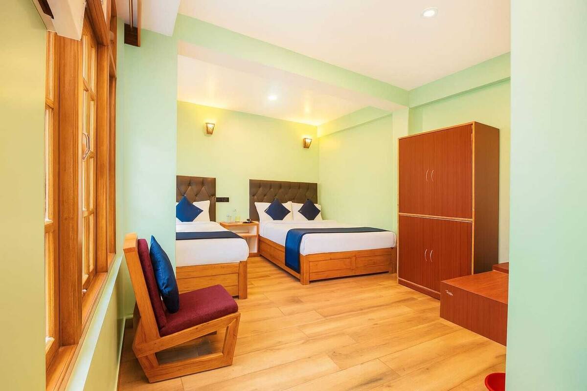 Ein Hotelzimmer mit zwei Betten, Holzmöbeln und einem Kleiderschrank.