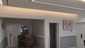 Een gang met een eethoek, een boekenkast, een kaart aan de muur en een deur die naar een andere kamer leidt.