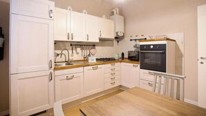 A compact kitchen with white cabinets, a wooden countertop, a stove, and a sink. - CASA AL GELSO, authentic Tuscan atmosphere (Lucca)