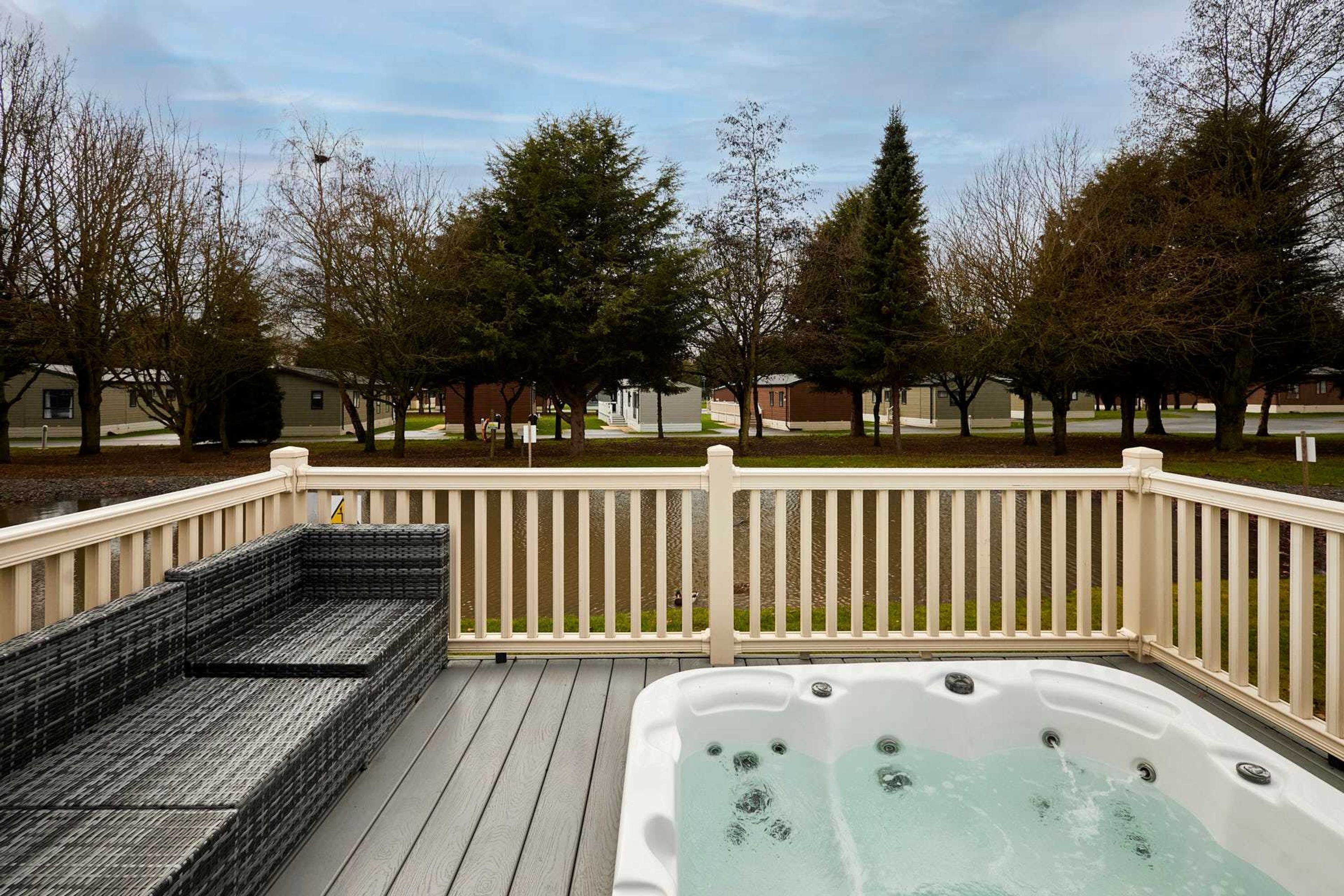 A deck with a hot tub and outdoor seating.