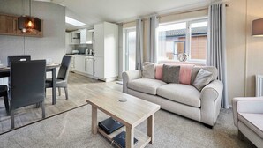 Ein modernes Wohnzimmer mit Sofa, Couchtisch und Essbereich.