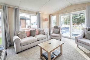 Ein modernes Wohnzimmer mit Sofa, Sessel und Couchtisch.