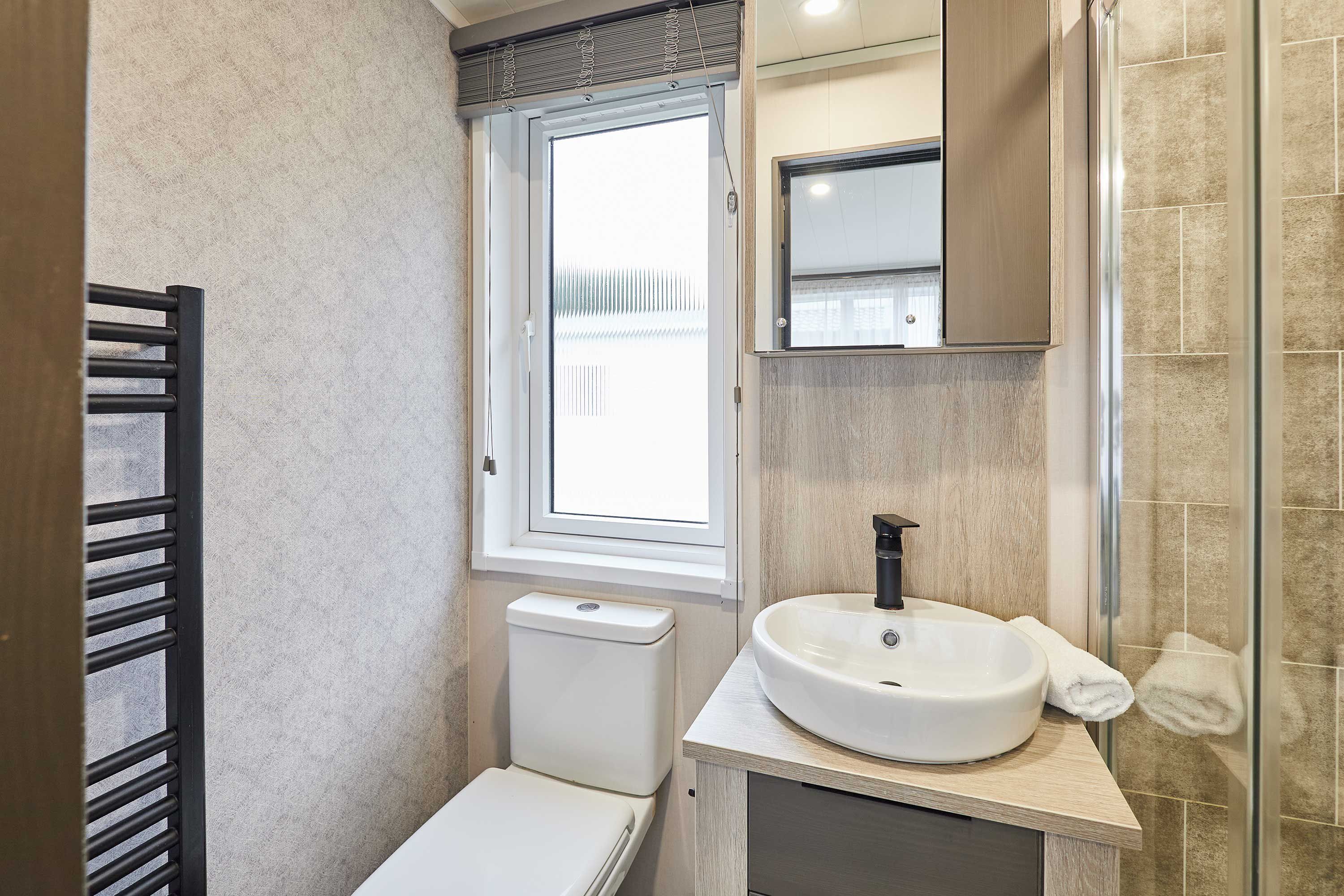 Une salle de bain moderne avec des toilettes, un lavabo et une fenêtre.