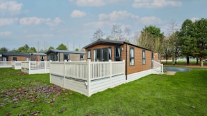 A row of modern mobile homes with white railings and a grassy lawn. - Host Stay Fairview Lodge (York)