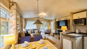 A cozy interior with a dining area, kitchen, and seating space. - Host Stay The Major Oak Lodge (York)