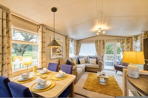 A cozy living room with a dining area, a sofa set, and a lamp. - Host Stay The Major Oak Lodge (York)