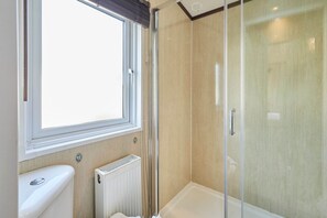 A bathroom with a window, a toilet, a radiator, and a shower enclosure. - Host Stay Lakeside Gem Lodge (York)