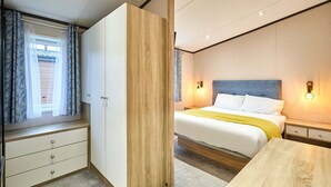 A bedroom with a bed, bedside tables, a wardrobe, and a window with curtains. - Host Stay Truemans Lodge (York)