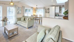 Ein geräumiges Wohnzimmer mit einer Couch, einem Couchtisch und einem Essbereich mit Tisch und Stühlen.