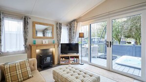Ein gemütliches Wohnzimmer mit Kamin, Fernseher und einer Couch.