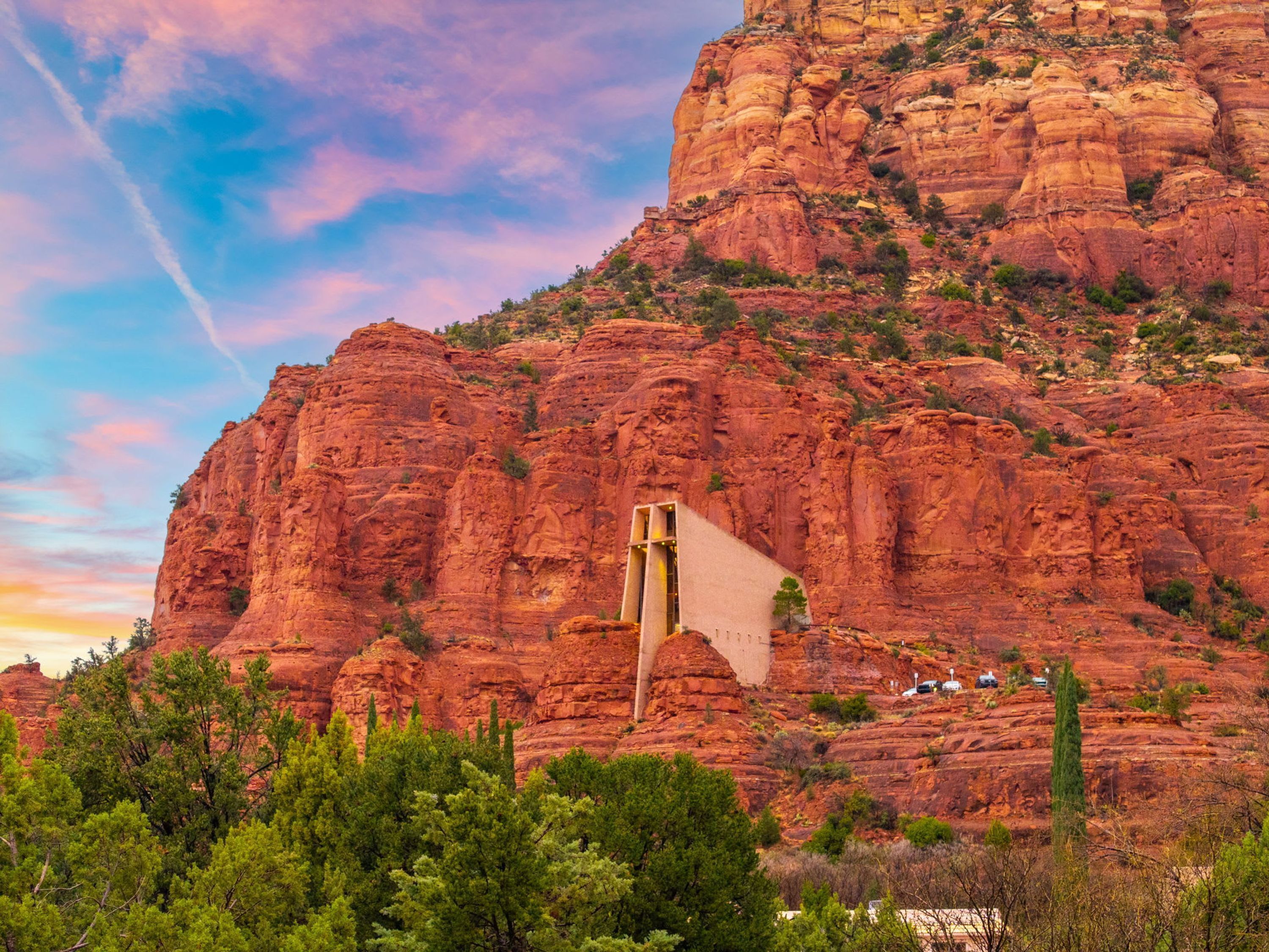 A mountain with a large rock formation and a structure with a pointed roof.