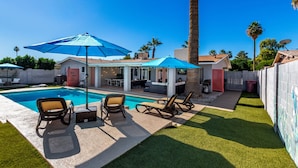 A backyard with a swimming pool, lounge chairs, and umbrellas. - NEW - The Desert Bloomhouse With Heated Pool (Scottsdale)