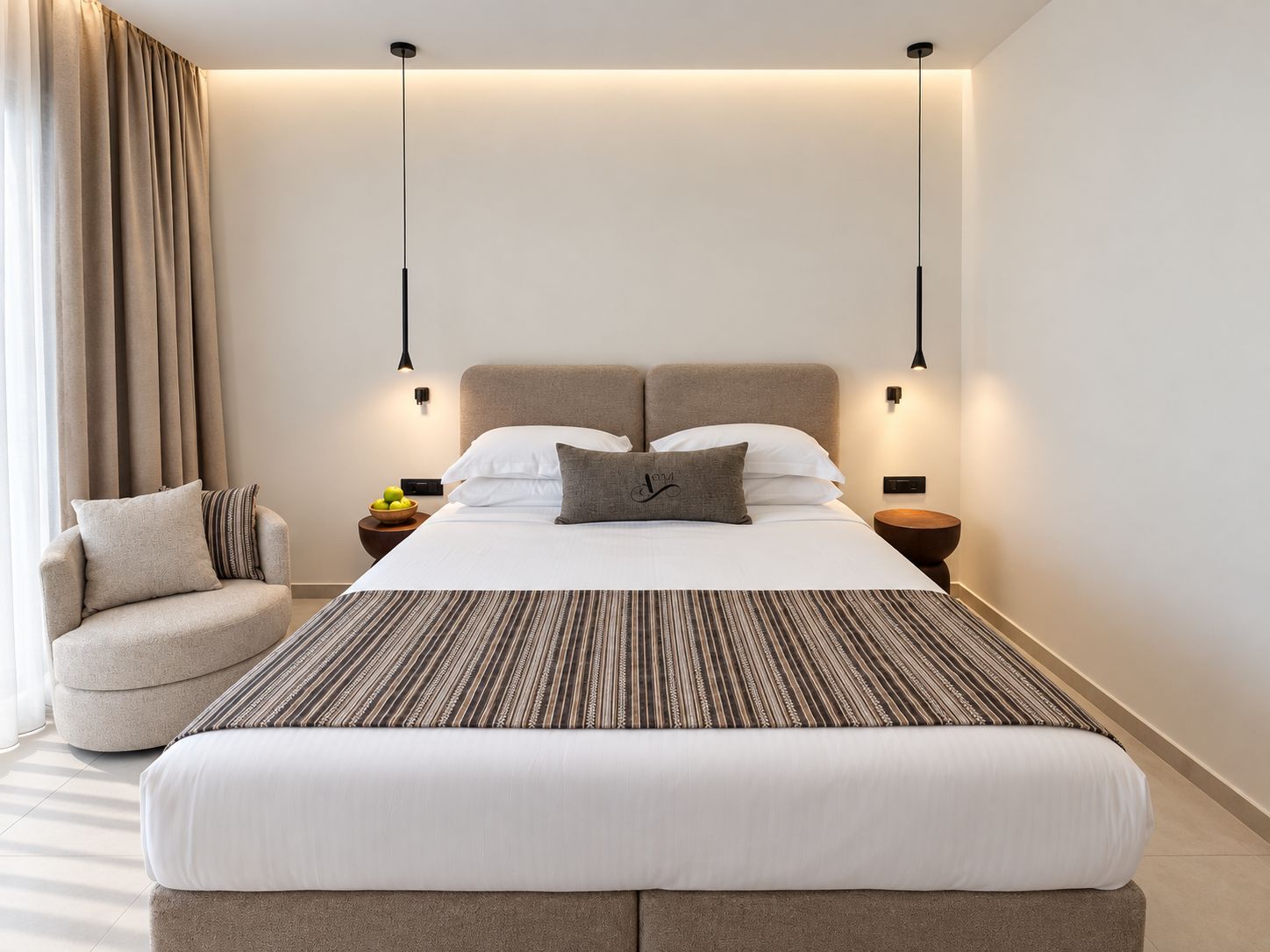 Une chambre d’hôtel moderne avec un grand lit, un canapé et deux tables de chevet.