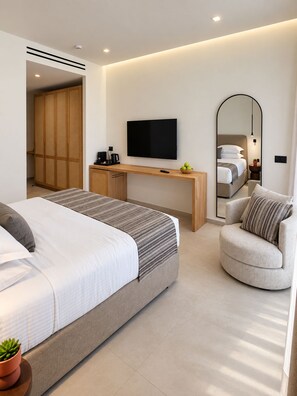 A modern hotel room with a bed, a desk, a television, a chair, and a wardrobe. - Agali Hotel Milos (Milos)