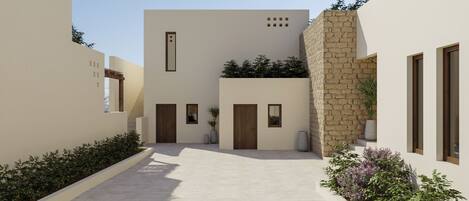 A modern building with a courtyard, featuring a mix of plain and stone facades, and minimalistic design elements.
