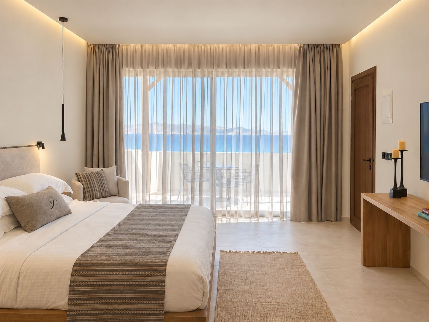 Un dormitorio con cama, mesita de noche y vistas al mar.