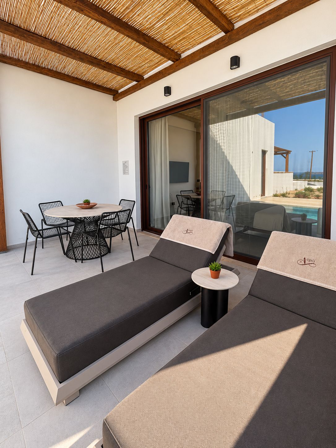 Ein moderner Außenbereich mit Pool, inklusive Liege und Tisch mit Stühlen.