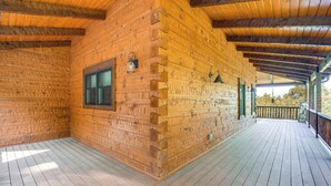 Une cabane en bois avec une véranda couverte et une fenêtre.