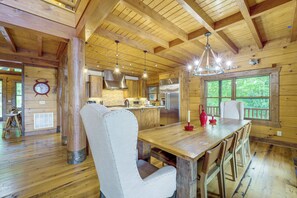 A wooden interior with a dining area, kitchen, and large windows. - Game Room + Deck: Spacious Spruce Pine Retreat! (Spruce Pine)