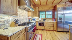Une cuisine avec des meubles en bois, une cuisinière en acier inoxydable et un réfrigérateur.