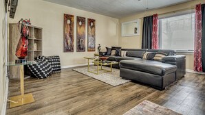 A living room with a sofa, coffee table, and artwork on the wall.
