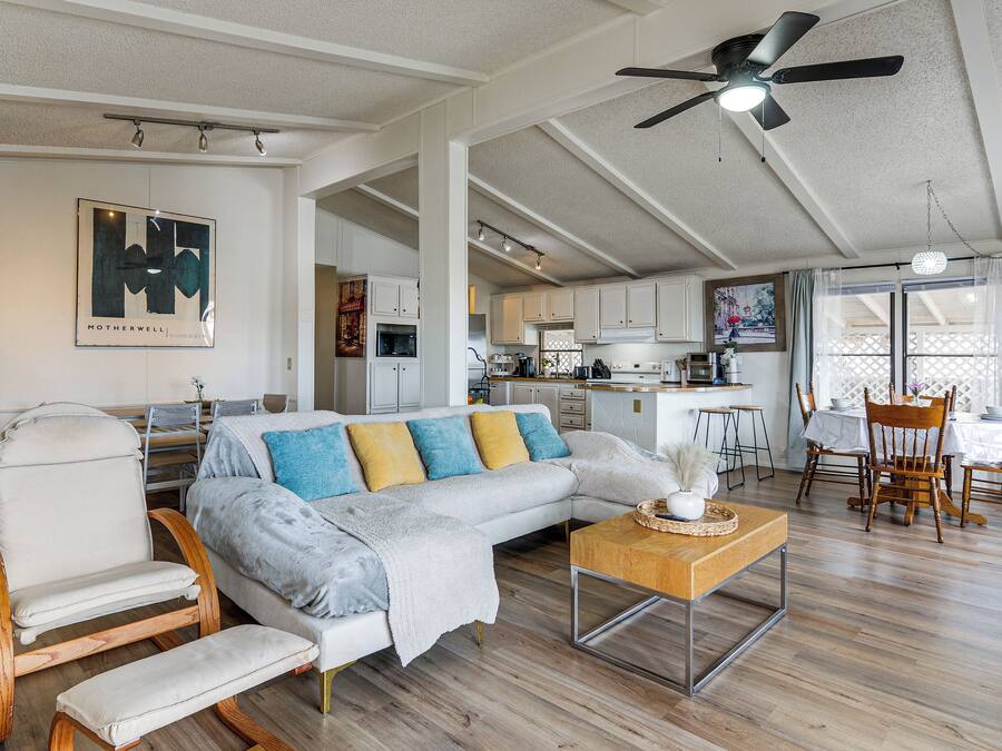 A spacious living area with a sofa, a rocking chair, and a dining table with chairs.