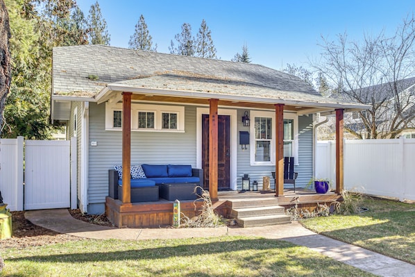 A single-story house with a covered porch, a front door, and a small front yard.