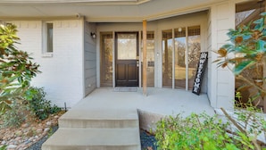 A house with a front porch, a dark front door, and a welcome sign. - Lakeside Retreat: Large Spacious Home w/ Game Room (Kemp)