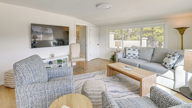 A modern living room with a sofa, armchairs, a coffee table, and a TV mounted on the wall. - Herrington Lake Home w/ Deck: Golf, Boat & Relax! (Danville)
