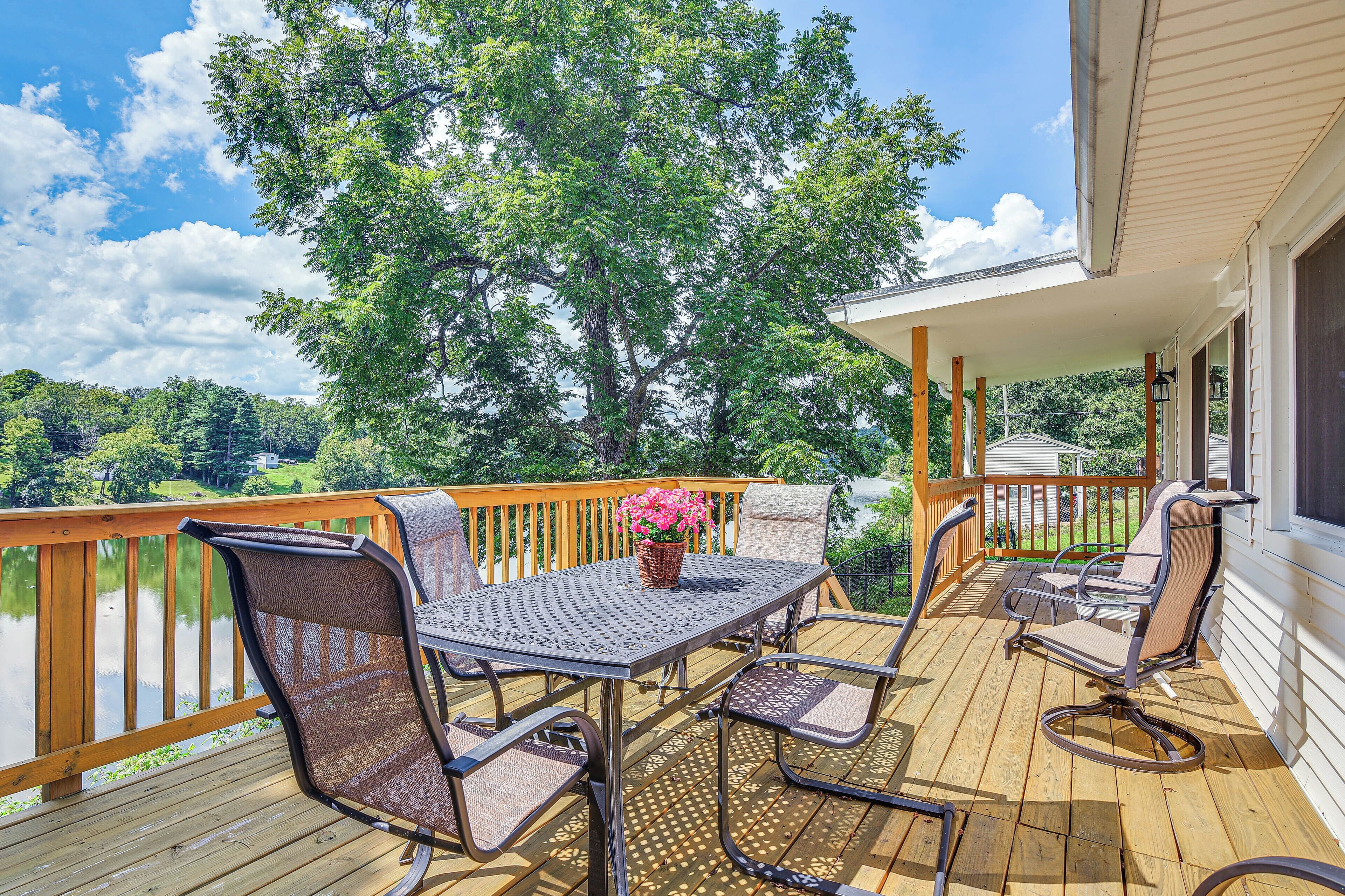 A wooden deck with outdoor furniture, a table, and chairs.